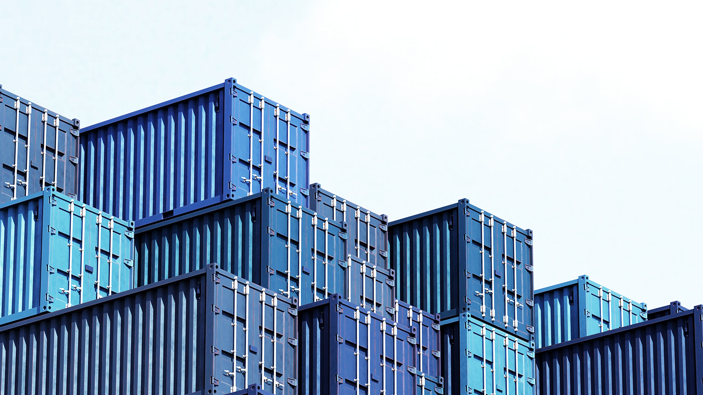 Blue shipping containers stacked with a view of the sky